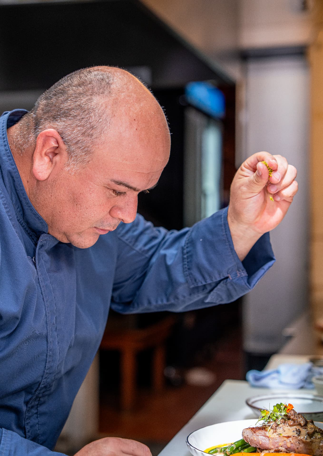 Chef Esteban Ortiz finishing a dish with a delicate garnish